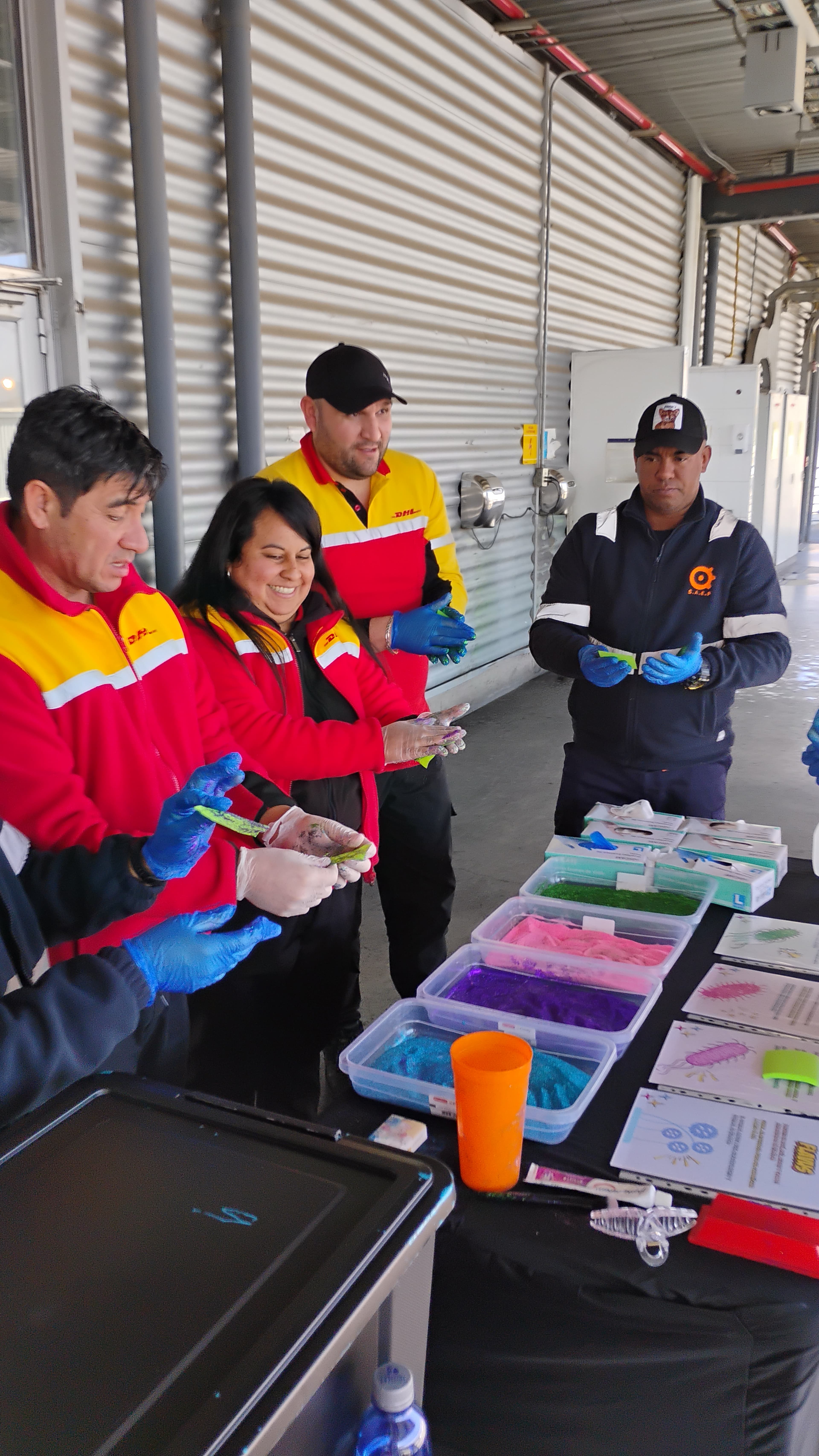 Equipo de una empresa manipulando slime de colores con guantes durante una actividad corporativa